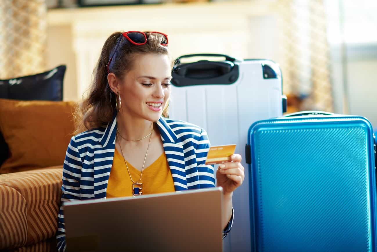 Voyager sans exposer sa carte bancaire 5 Voyageuse utilisant une carte bancaire pour ses achats en ligne, sans révéler ses informations sensibles.