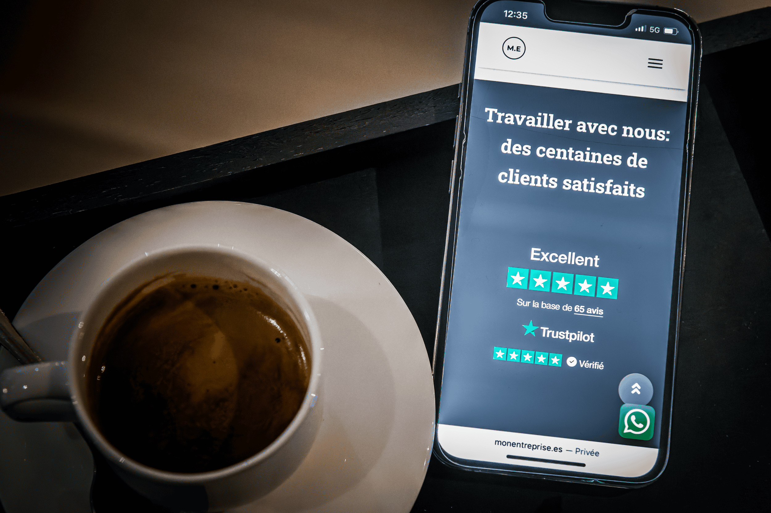 Smartphone affichant un avis client positif avec une tasse de café à côté, illustrant la confiance et la satisfaction des clients pour un cabinet fiscal en Espagne.