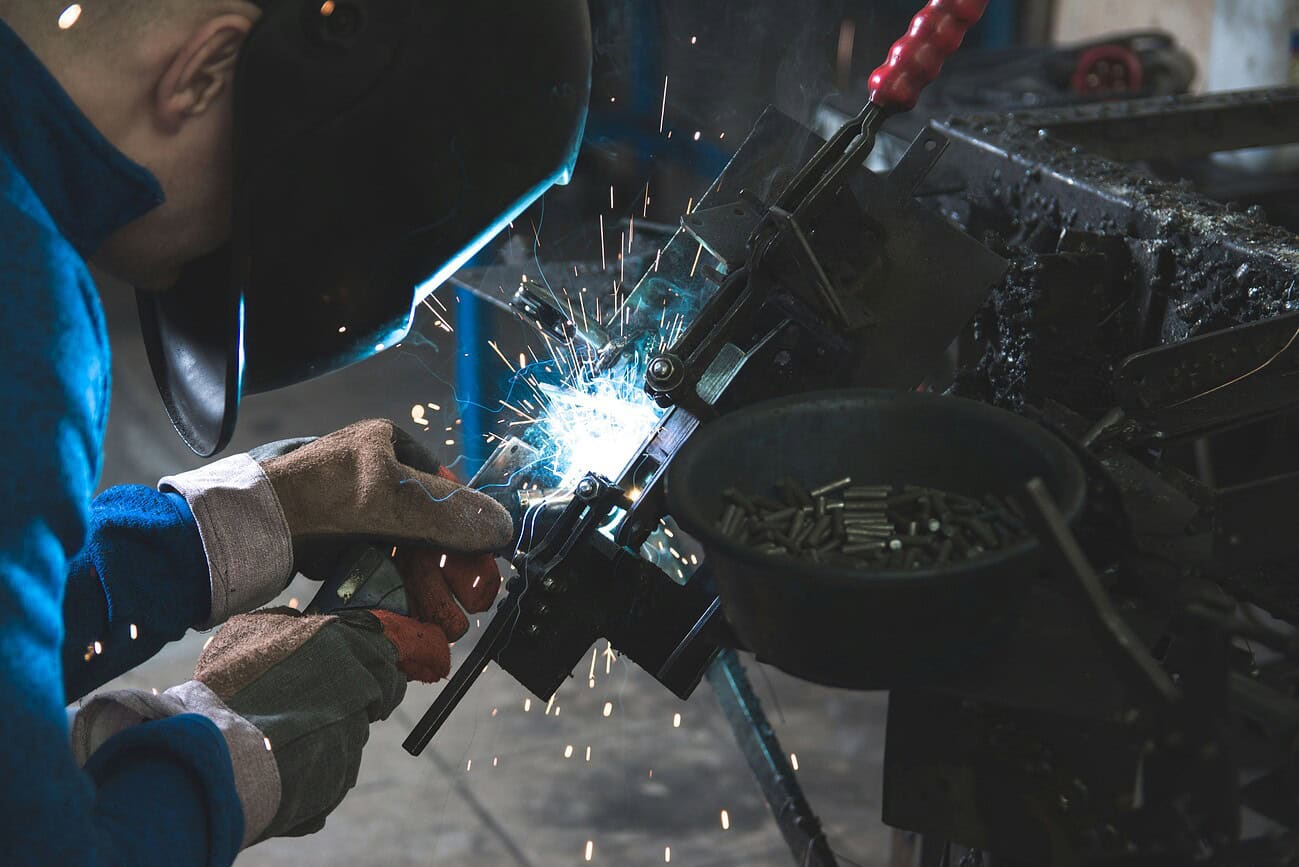 Soudure professionnelle dans un atelier de tôlerie, illustrant la sécurité et la conformité avec un tiers indépendant.