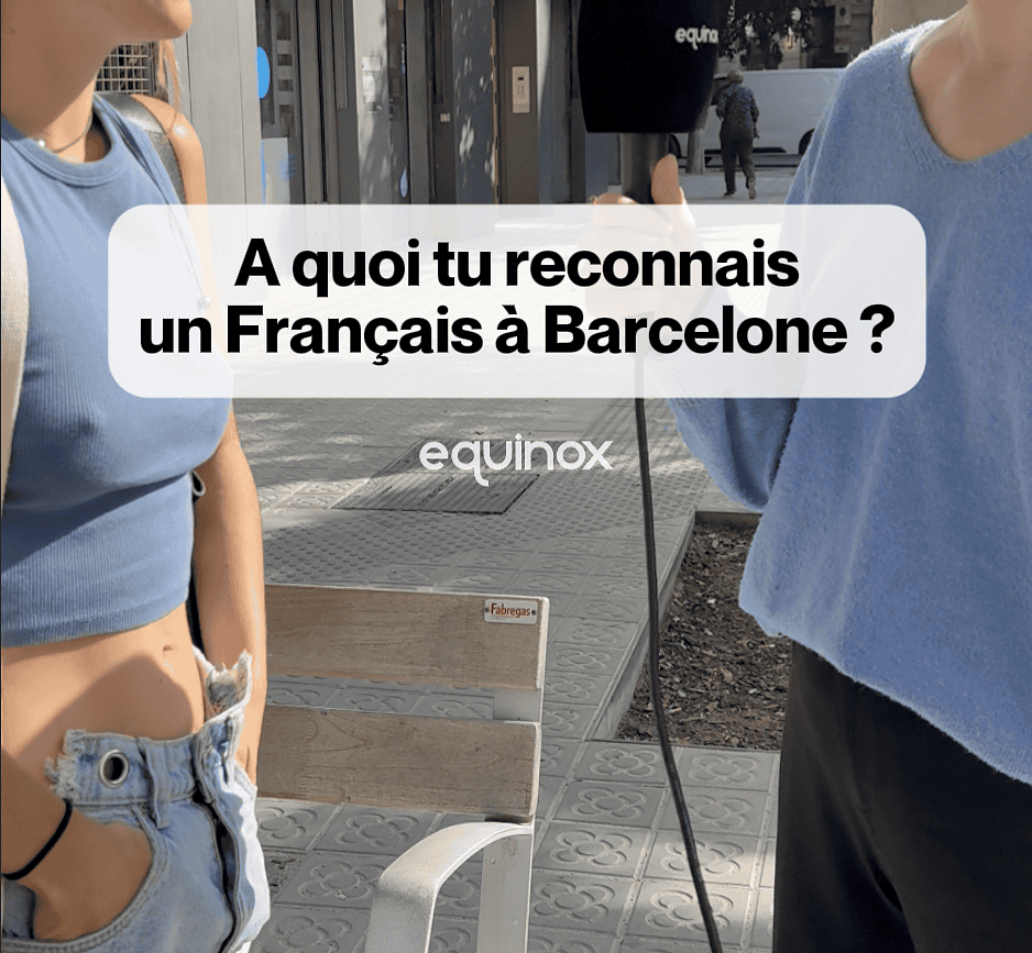 Deux jeunes femmes discutent à Barcelone, l'une tient un smartphone pour interviewer l'autre, dans un contexte urbain ensoleillé.