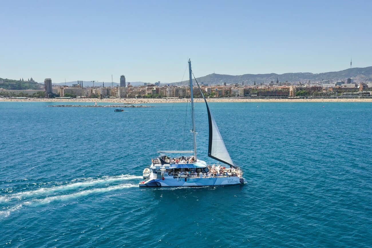 Cette activité est en train de s’imposer comme un futur incontournable à Barcelone 1 Bateau de croisière naviguant dans la mer Méditerranée avec la ville de Barcelone en arrière-plan, illustrant une activité maritime tendance en plein essor.