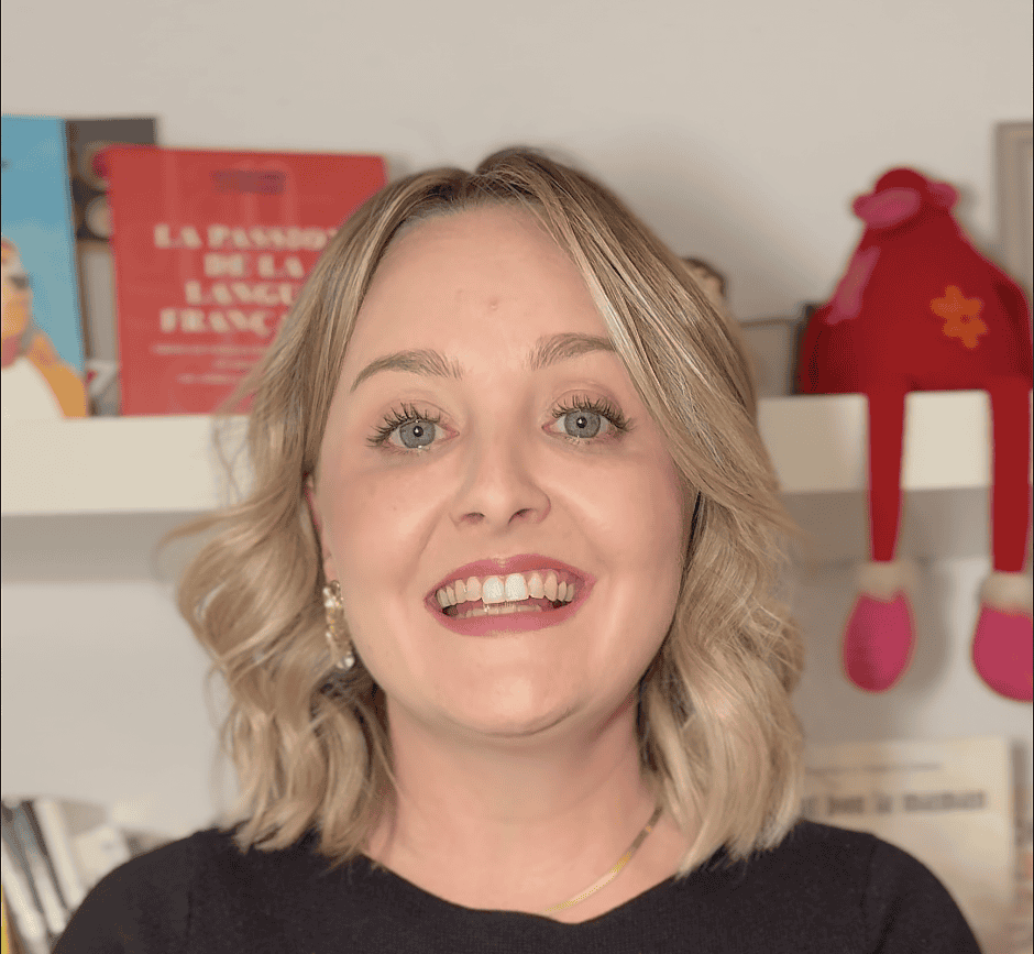 Image de femme souriante avec un bébé en peluche, portant un pull noir avec le texte "Parents en Espagne : les démarches".