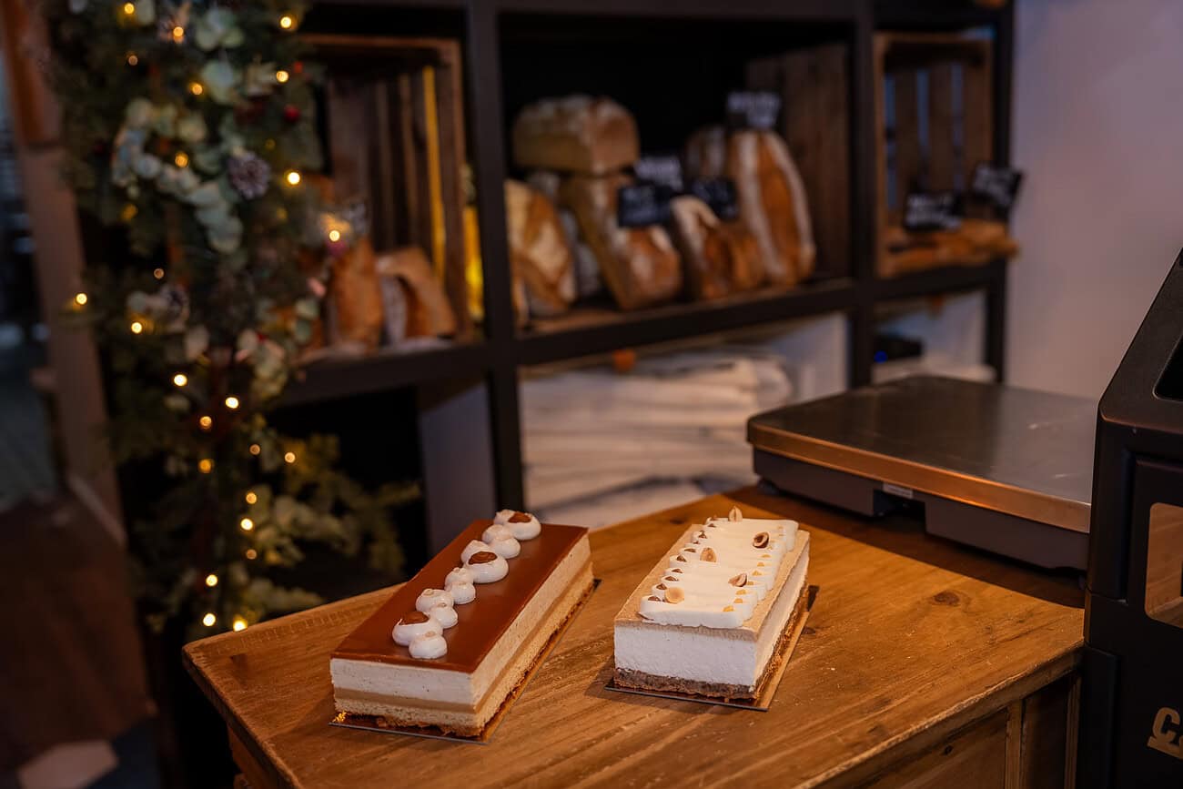 Bûches de Noël artisanales exposées chez Le Pain d’Éric & Benjamin à Barcelone, mettant en valeur leur savoir-faire en pâtisserie traditionnelle pour les fêtes de fin d’année.