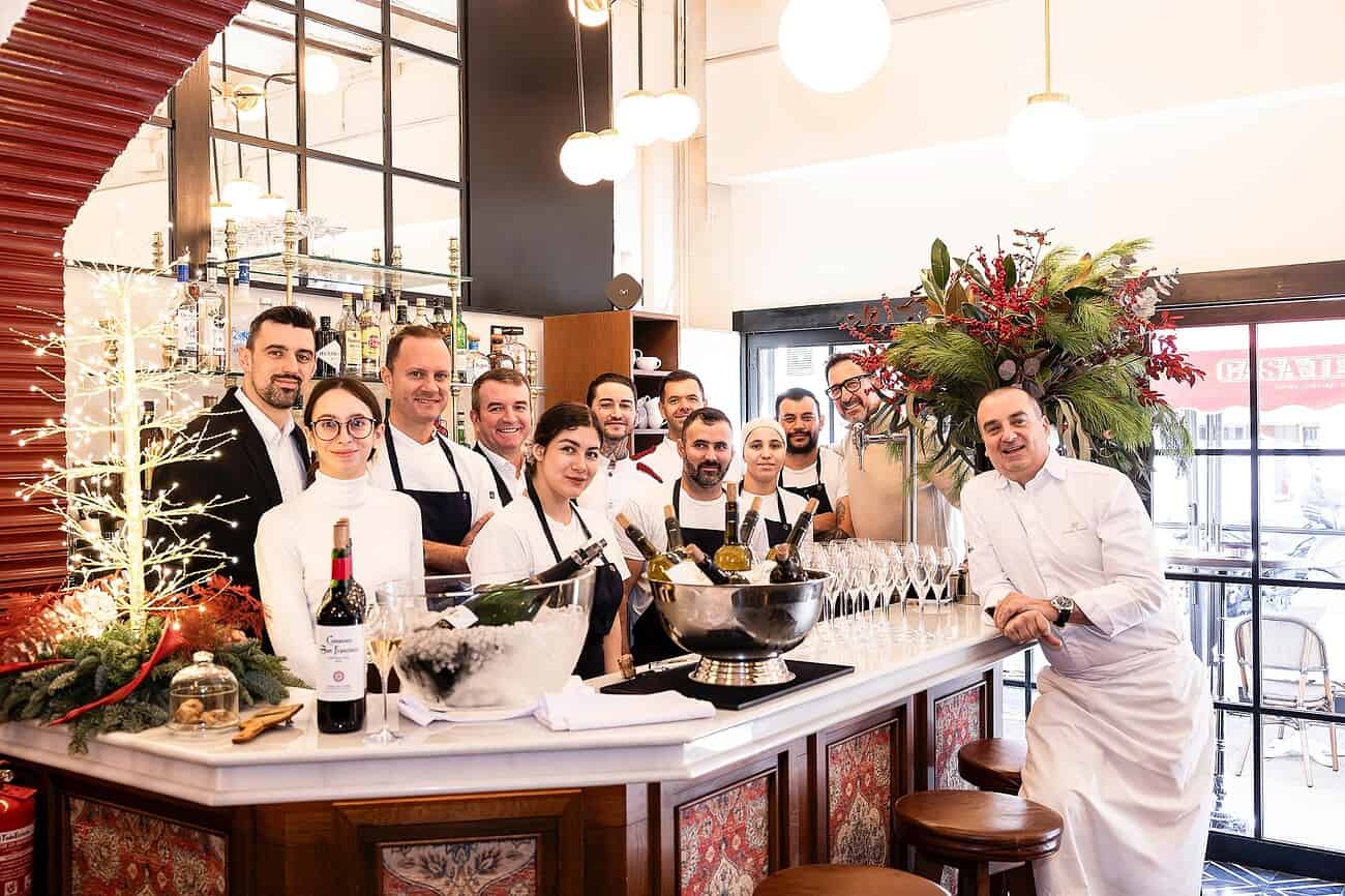 “Un bistrot français aux influences italiennes” : la renaissance de Casa Tejada à Barcelone 4 Bistrot français Casa Tejada à Barcelone, influencé par l'Italie, avec une équipe de serveurs souriants derrière le bar, décor chaleureux et ambiance conviviale.