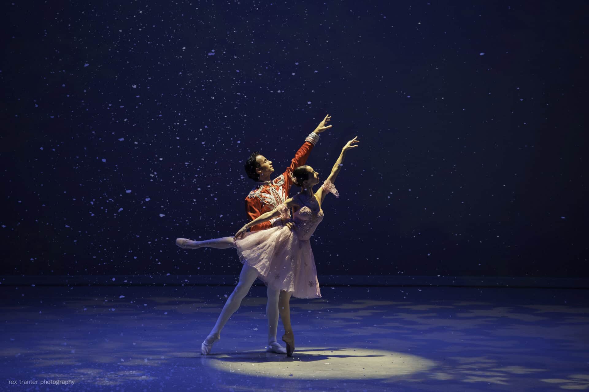 Danseurs en scène lors d'une performance artistique sous un ciel étoilé, illustrant la beauté de la danse et de l'art en plein air à Barcelone.