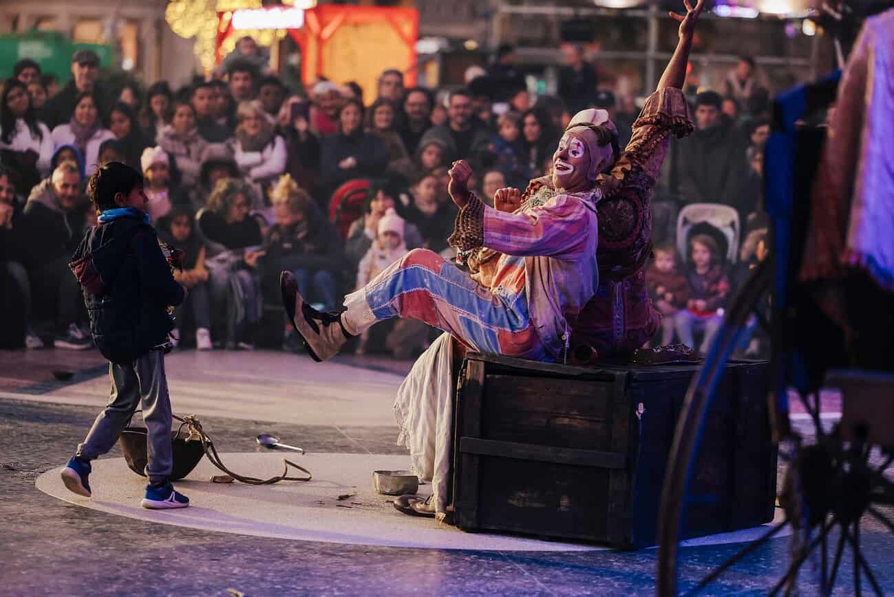 Que faire à Barcelone le week-end du 19 au 21 décembre 1 Artiste de rue en costume coloré lors d'une performance en plein air à Barcelone, attirant un large public.