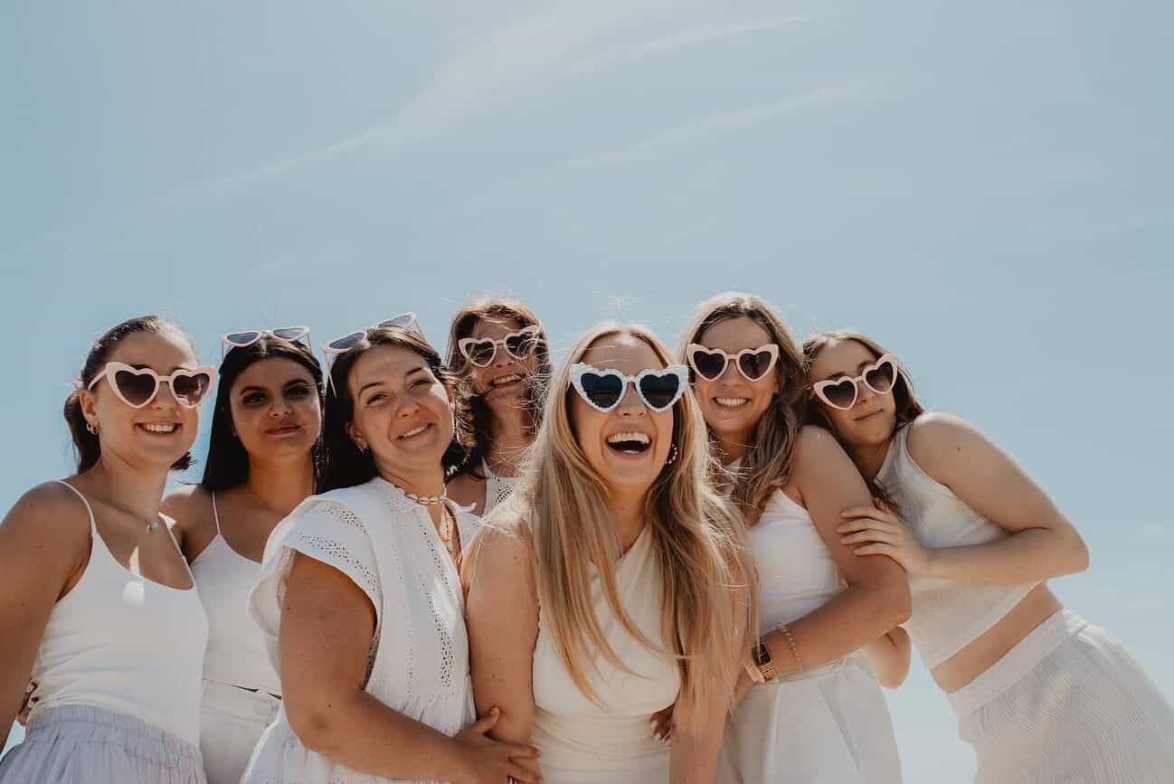 Équinox, EVJF à Barcelone en 2026, groupe d'amies souriantes portant des lunettes de soleil en forme de cœur, profitant d'une journée ensoleillée pour un enterrement de vie de jeune fille moderne et i.