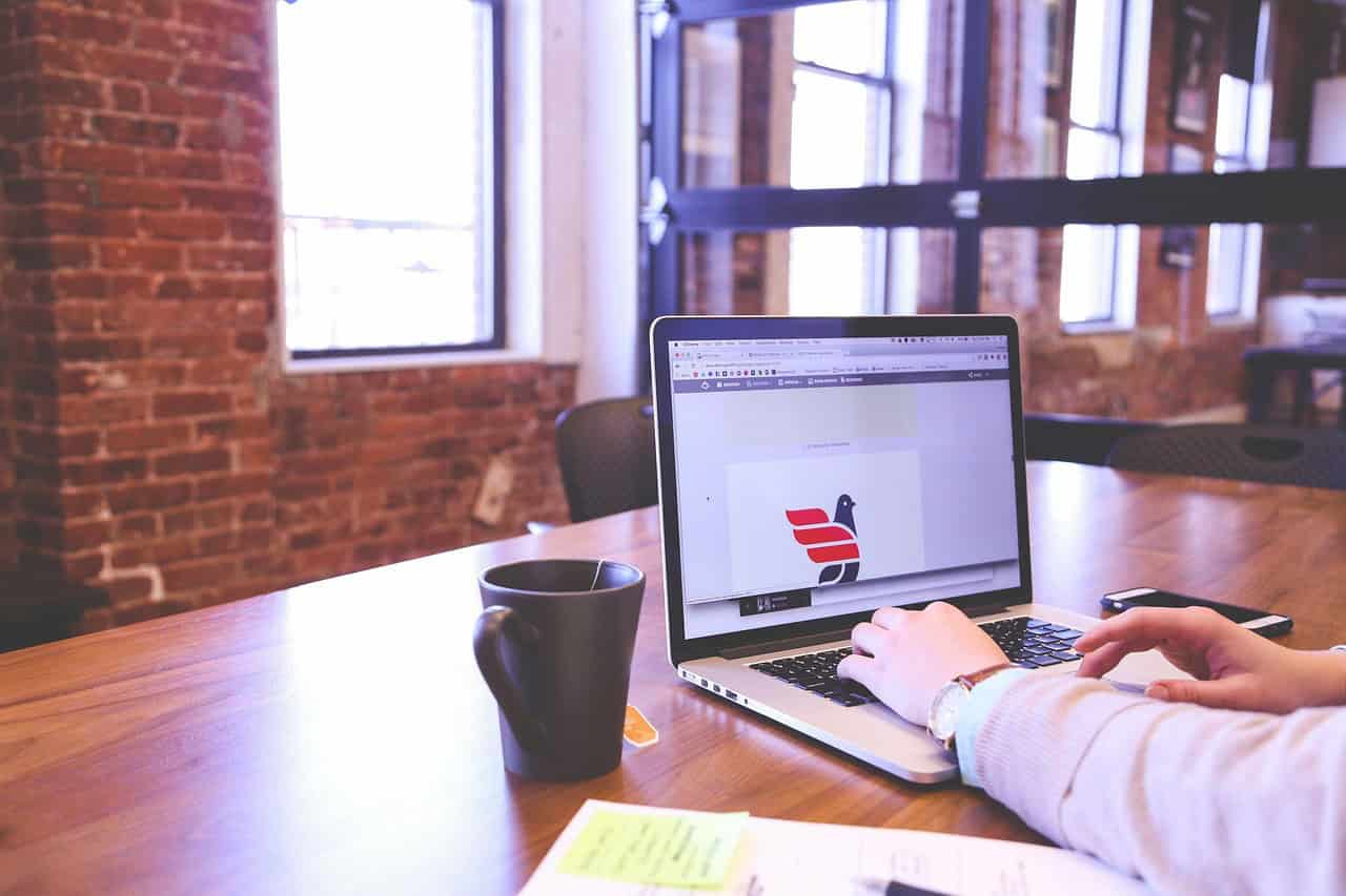 Espace de coworking moderne avec ordinateur portable et café, illustrant la diversité des espaces de travail partagés dans les grandes villes européennes.