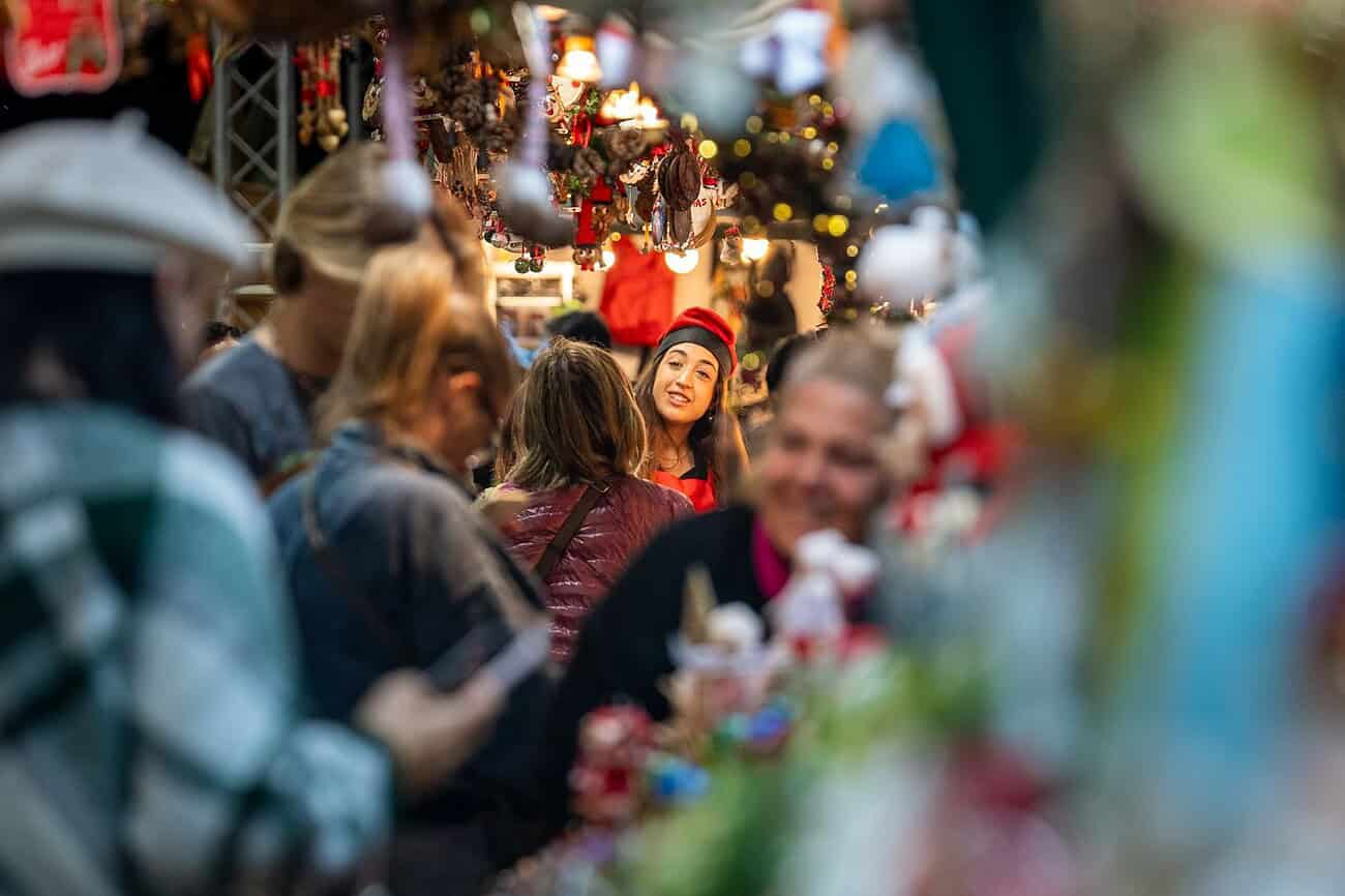 Que faire à Barcelone le week-end du 5 au 8 décembre 2025 1 Balade dans un marché de Noël animé avec des visiteurs découvrant des stands de cadeaux et de gourmandises.