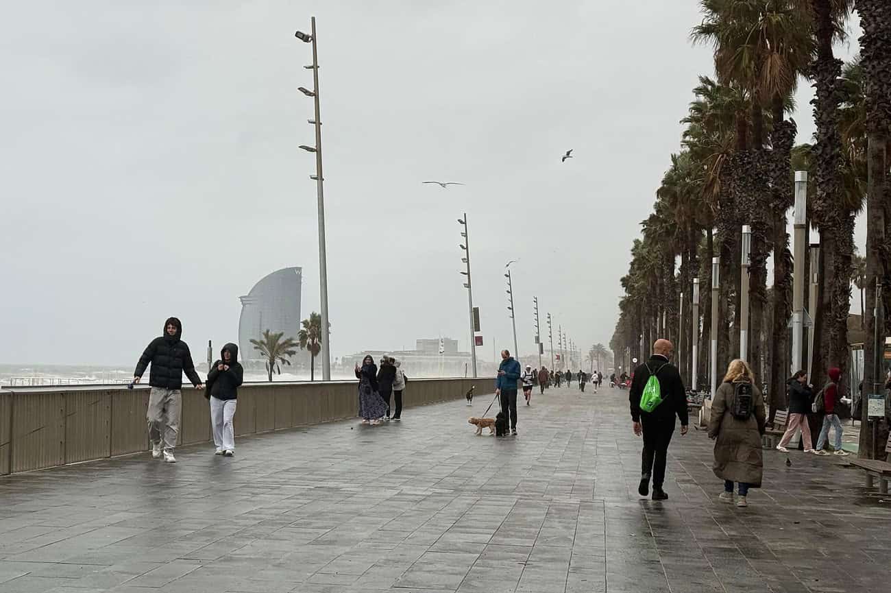 L’Espagne paralysée par une alerte vent et neige 1 Tempête maritime intense à Barcelone et sur la Costa Brava, avec des vagues puissantes et des vents forts, impactant la promenade et les passants.