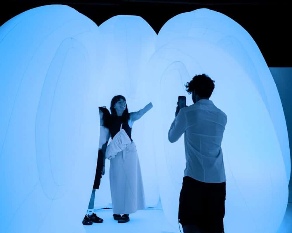 Deux personnes participent à une expérience immersive à Antarctica Experience Barcelone, avec un décor lumineux évoquant un environnement polaire, lors d’un événement de networking.