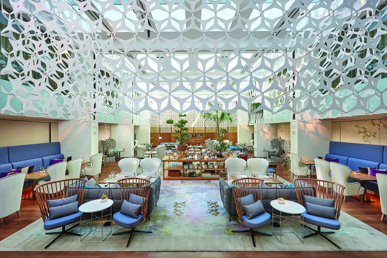 Balcon intérieur lumineux du restaurant Blanc au Mandarin Oriental, avec mobilier moderne et ambiance chaleureuse.