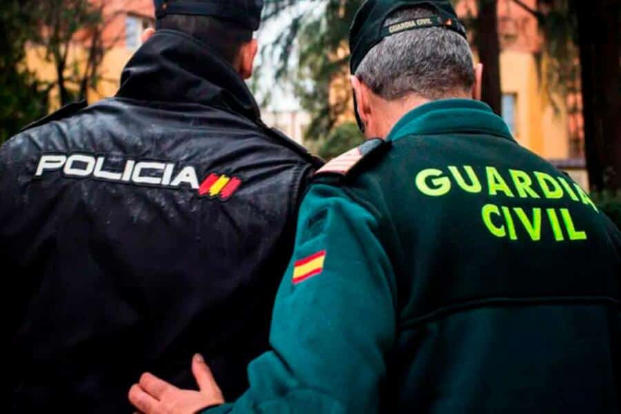 Deux agents de police et de la garde civile espagnole en conversation, symbolisant la coopération entre forces de l'ordre dans le contexte de l'immigration clandestine.