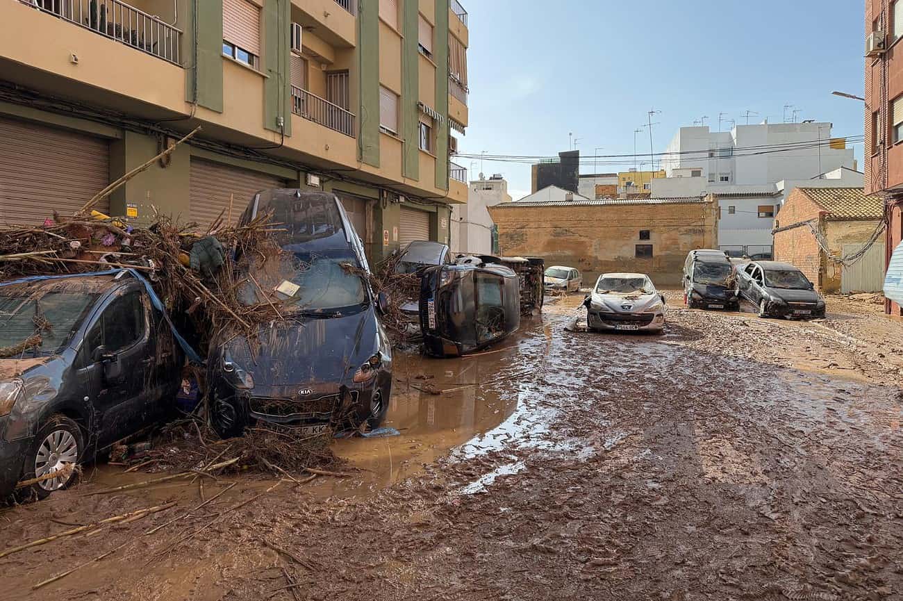 Pourquoi Barcelone échappe aux pires inondations 2 Inondations urbaines à Barcelone causées par de fortes précipitations, avec des voitures endommagées et des rues inondées, illustrant la vulnérabilité face aux inondations dans la ville.