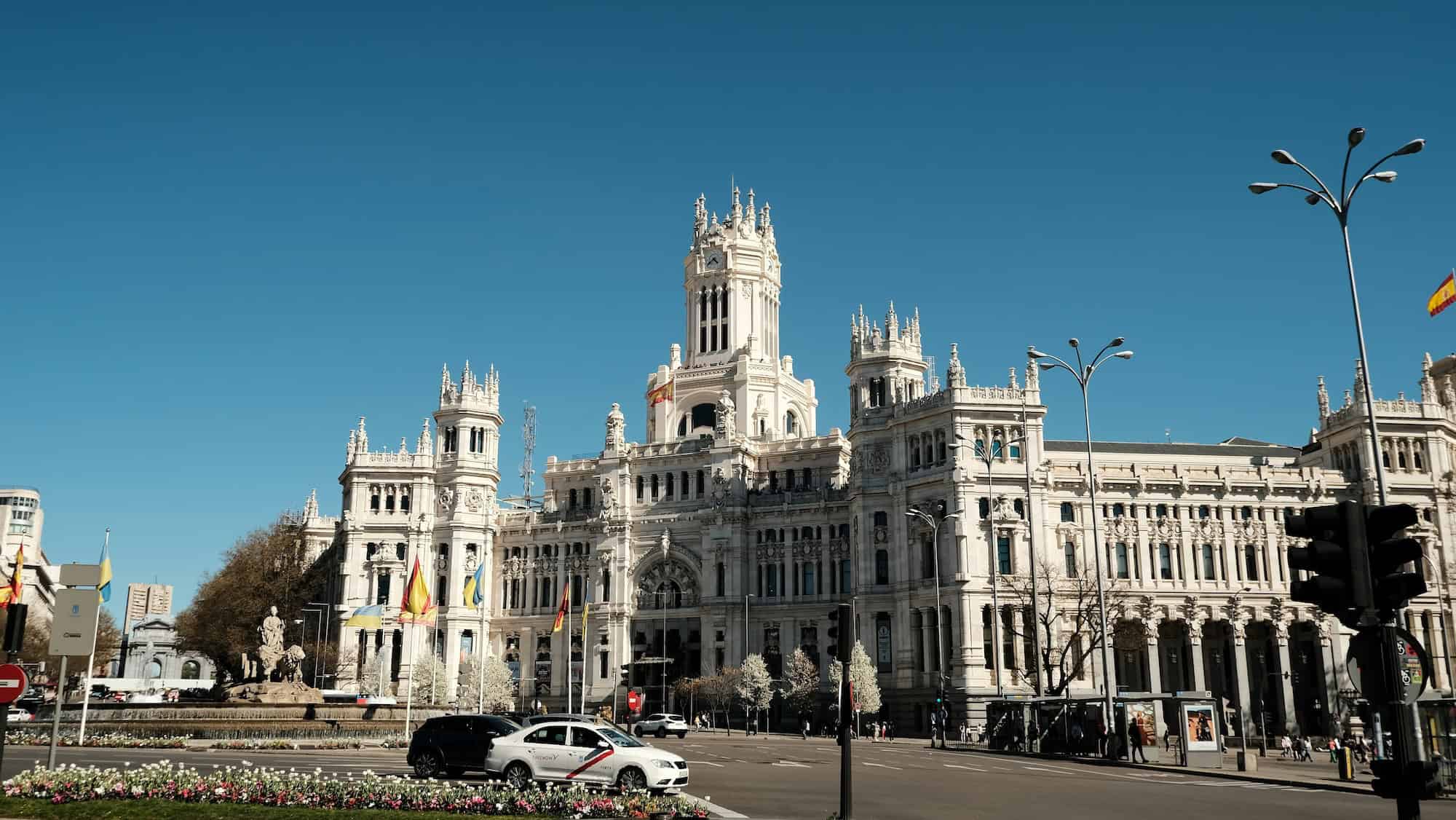 Balade devant l'hôtel de ville historique de Madrid sous un ciel bleu clair.