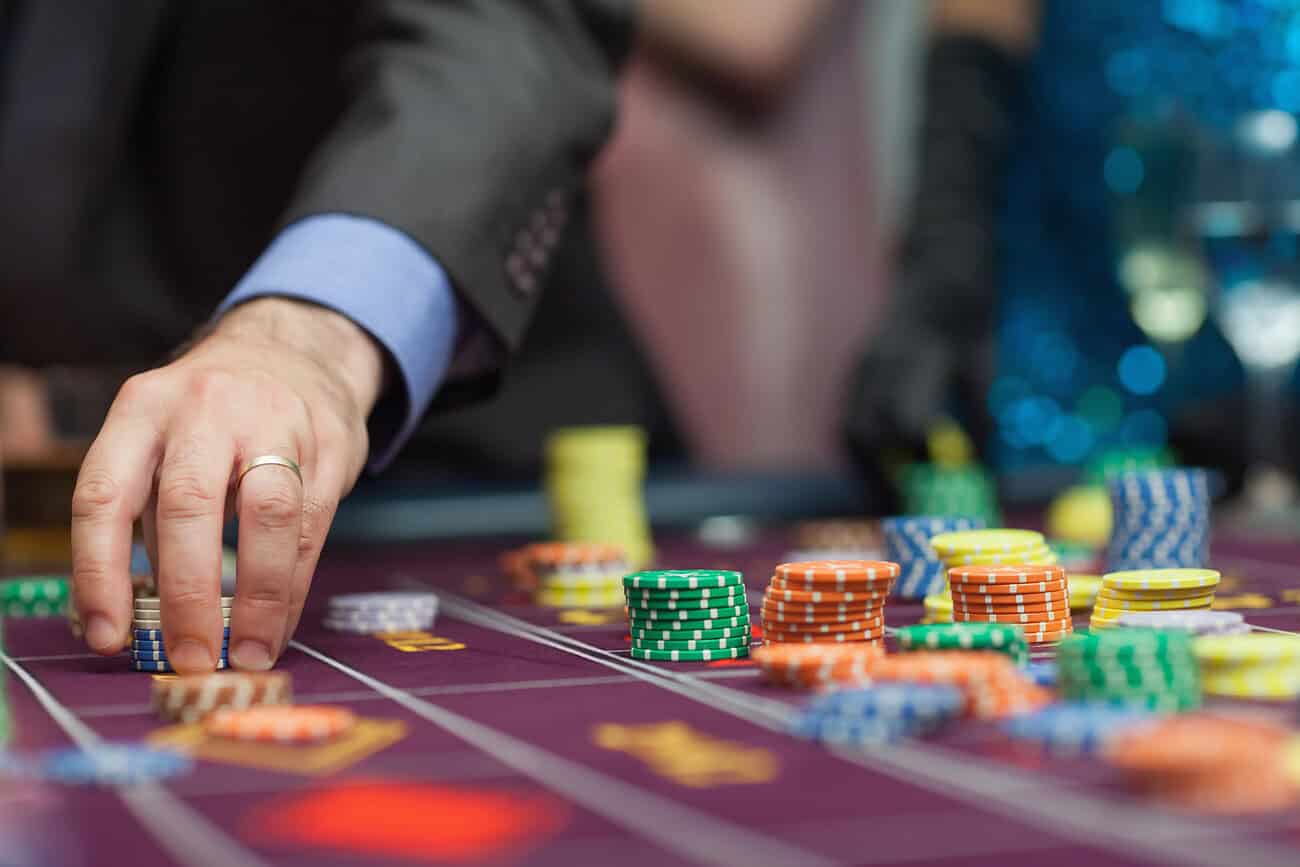 Quels jeux trouve-t-on sur un casino en ligne belge et comment fonctionnent-ils ? 1 Jeux de casino en ligne belge avec jetons colorés sur une table de jeu.