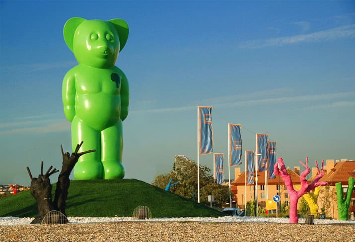 Énorme sculpture de ours vert géant à La Ciudad de los Niños, un site touristique populaire en Espagne, connu pour ses œuvres d'art insolites et ses attractions familiales.