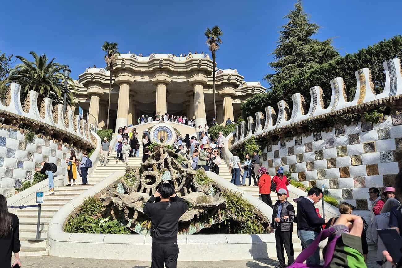 Vue du célèbre parc Güell avec ses mosaïques colorées et ses structures architecturales uniques, attirant de nombreux visiteurs.