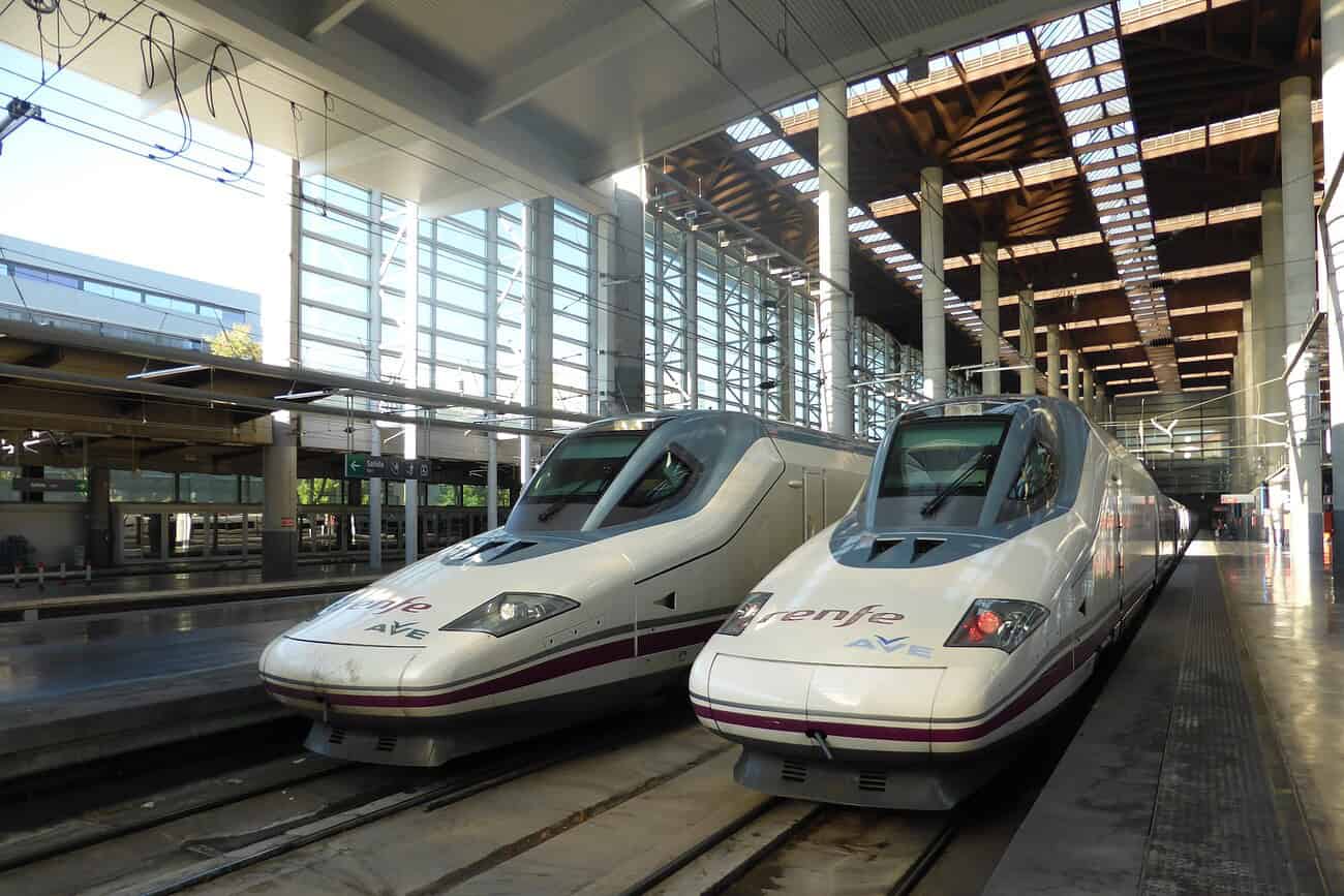 Deux trains à grande vitesse modernes dans une gare, symbolisant le projet de liaison ferroviaire directe entre Paris, Madrid et Lisbonne, pour renforcer la connectivité européenne.